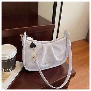 Gros plan détaillé du sac seau plissé violet clair avec chaîne décorative à breloques cœur