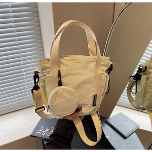 Detail of cream nylon bucket bag with round coin purse and wide shoulder strap