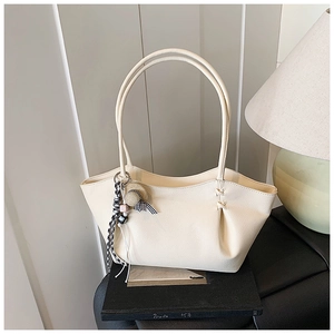 Detail of off-white lychee grain leather tote with mini hat and checkered ribbon charm