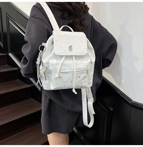 Dettaglio dello zaino in nylon bianco con stelle e fibbia argentata sulla modella