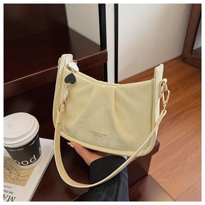 Détail du sac seau plissé jaune clair avec pendentif cœur et texte imprimé mode