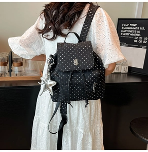 Detail of black nylon backpack with star prints, silver g-buckle and star charm detail