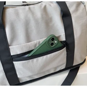 Detail of travel bag side pocket showing storage capacity for a smartphone