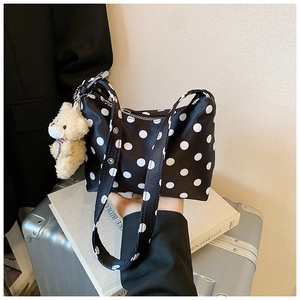 Detailansicht der schwarzen Polka-Dot-Tasche mit Plüschbär-Anhänger und Reißverschluss