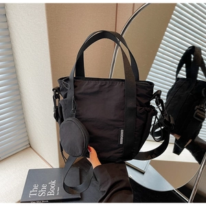 Detail of black nylon two-in-one bucket bag with drawstring and small round pouch