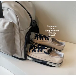 Detail view of light grey travel bag with a separate shoe compartment for easy storage