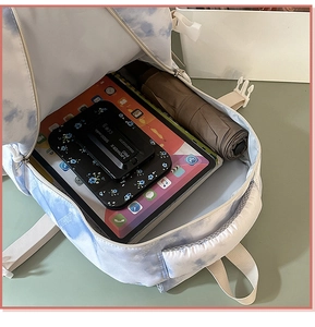 Top view of tie-dye backpack interior showing large capacity for tablet and accessories
