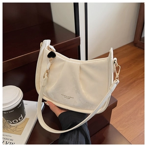 Détail du sac seau plissé blanc cassé avec boucles dorées et breloque en cœur