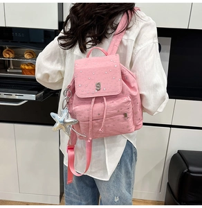 Detailed close-up of pink backpack with silver star patterns and cute star charm