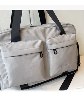 Detail of lightweight travel bag showing smooth zippers and MULAIDISS embroidery