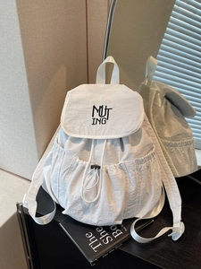 Minimalist white nylon backpack with drawstring closure and black letter embroidery