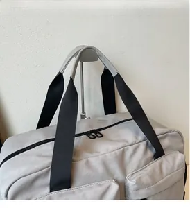 Close-up of durable grey canvas travel bag featuring reinforced handles and dual zippers