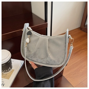 Détail d'un sac en daim bleu avec chaîne à cœurs et inscription de mode élégante