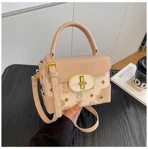 Detalle de bolso bandolera beige y rosa con estampado de osito y cierre de broche dorado