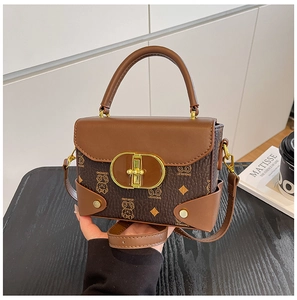 Detalle de bolso retro marrón con estampado de oso y cierre metálico ovalado en dorado