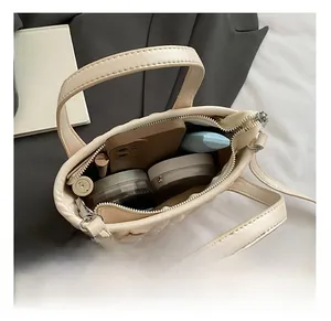 Interior view of quilted cream bag showing storage for phone and cosmetics