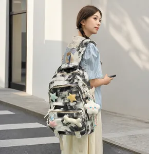 Tie-dye backpack detail with star patches, plush cloud and bone charms for students
