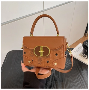 Detalle de un bolso bandolera de cuero marrón con cierre dorado y patrón de osos
