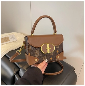 Detalle de bolso de mano vintage marrón con diseño de oso y cierre giratorio dorado