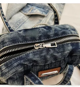 Detail of a high-quality smooth metal zipper on a washed blue denim pillow bag