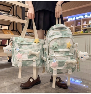 Detail of green tie-dye backpack and tote bag with plush charms in a modern cafe setting