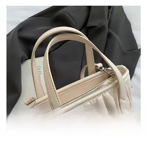 Close-up of beige quilted handbag with sparkling rhinestone accents and wavy stitching