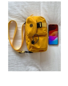 Detail of yellow nylon crossbody bag with multi-pocket storage and tactical buckle