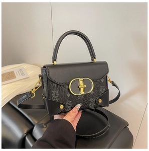 Detalle del bolso de cuero negro con estampado de oso y cierre metálico dorado