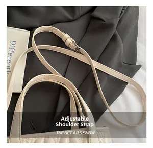 Detail showing the adjustable shoulder strap and quilted leather texture of the bag