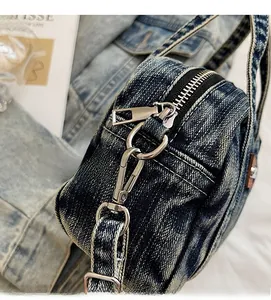 Close-up of polished silver hardware and high-quality zipper on blue denim handbag