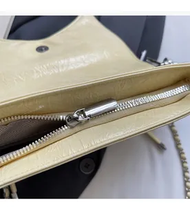Detail of smooth silver zipper closure and textured leather on a bow shoulder bag