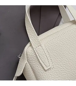 Détail du sac à main en cuir grainé blanc cassé avec coutures et fermeture éclair