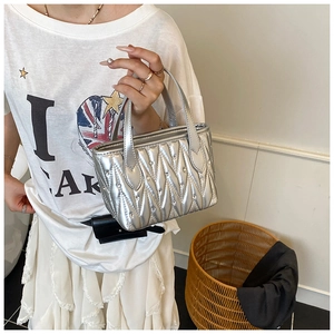Close-up of a silver quilted handbag with sparkling rhinestone accents and dual handles