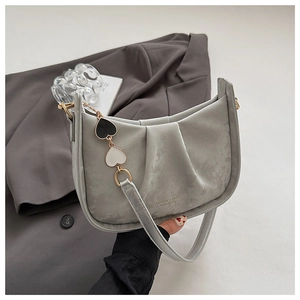 Détail du sac sous le bras plissé gris avec pendentif chaîne cœur noir et blanc