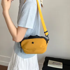 Sac bandoulière minimaliste en toile jaune en forme de coquille avec bandoulière assortie