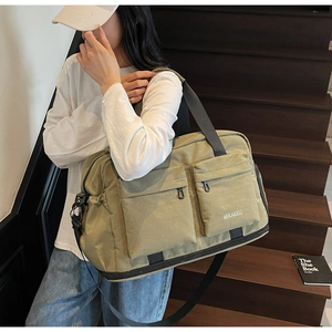 Olive green travel bag detail showing durable canvas fabric and front zipper pockets