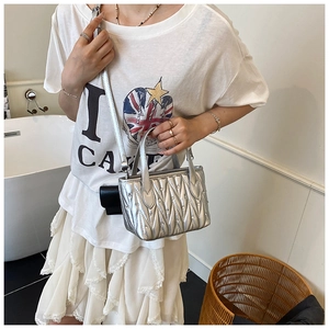 Close-up of silver quilted crossbody bag with stud accents and sleek chain strap