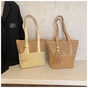 Detailed weave pattern of straw beach bags in cream and light brown with tassel charms
