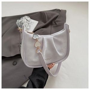 Détail du sac à bandoulière plissé lavande avec fermeture éclair dorée et pendentif cœur