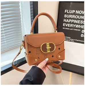 Detalle de mini bolso marrón vintage con osos en relieve y cierre metálico dorado
