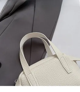 Détail de la poignée en cuir cousue sur le sac à main blanc cassé avec boucle argent