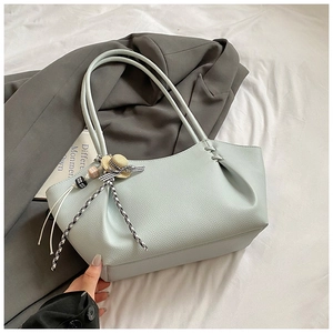 Close-up of light green lychee texture tote bag with sweet hat and ribbon charm detail