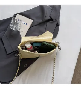Detail shot of the spacious interior of a creamy yellow glossy leather chain bag