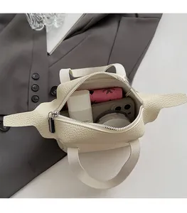 Vue de dessus de l'intérieur du sac à main en cuir crème montrant l'espace de rangement