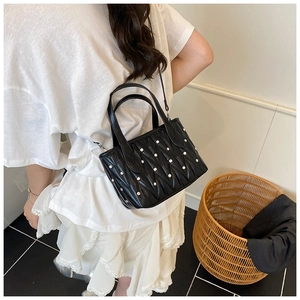 Detail of black matelassé crossbody bucket bag with silver studs and chain strap