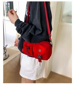 Detail of red nylon crossbody bag with flap pocket, black buckle and GM logo