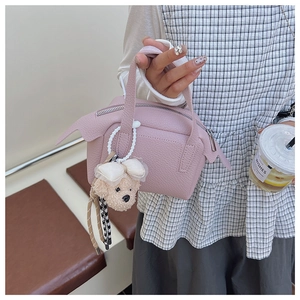 Détail du sac à main en cuir grainé rose avec un pendentif chiot en peluche mignon