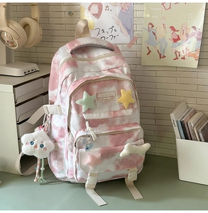 Detail of pink tie-dye backpack with cute star charms and soft school stationery aesthetic