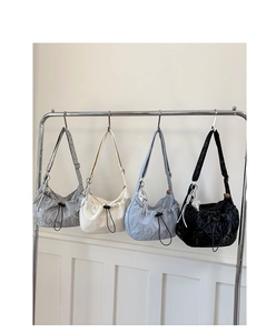 Detail view of colorful pleated crossbody bags with drawstring and star charm pendant