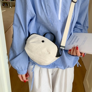 Chic cream canvas crossbody bag with black zipper detail and minimalist semi-circle design